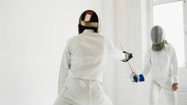 istock Two fencers having training attack exercises in fencing in studio 884505968