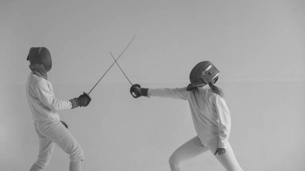 istock Two fencers having break after training attack exercises in fencing in studio indoors 884510616