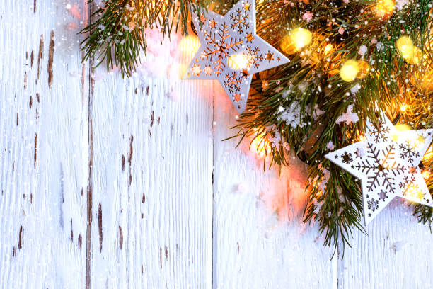 istock Christmas snowy background. Fir branches with burning garland 884512916