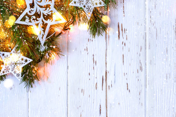 istock Christmas snowy background. Fir branches with burning garland 884512950