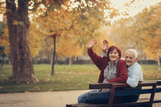 istock Happy autumn-senior couple on park bench 884524280