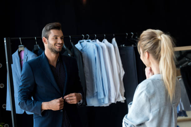 istock couple choosing suit in boutique 884525054