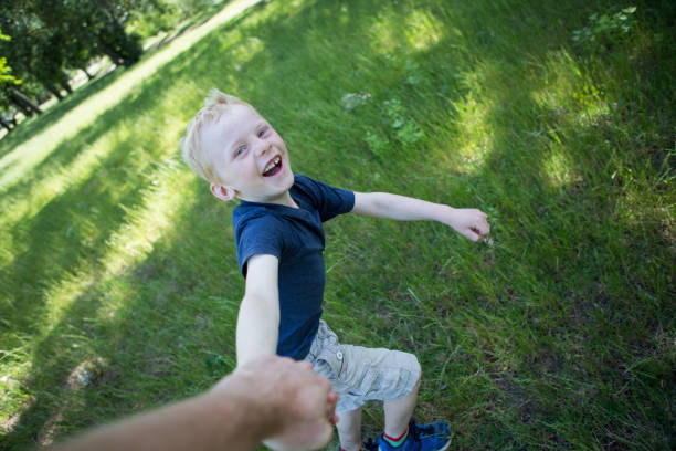 istock Boy running in circles holding dad's hand 884537036
