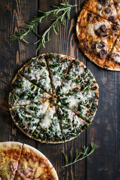istock Varied pizzas on a wooden table 884556962