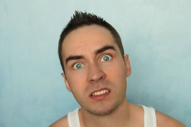 istock Portrait of young man with scared expression 884557286