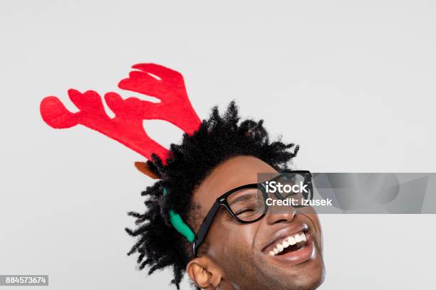 Christmas Portrait Of Happy Nerdy Man Wearing Reindeer Handband Hores Stock Photo - Download Image Now