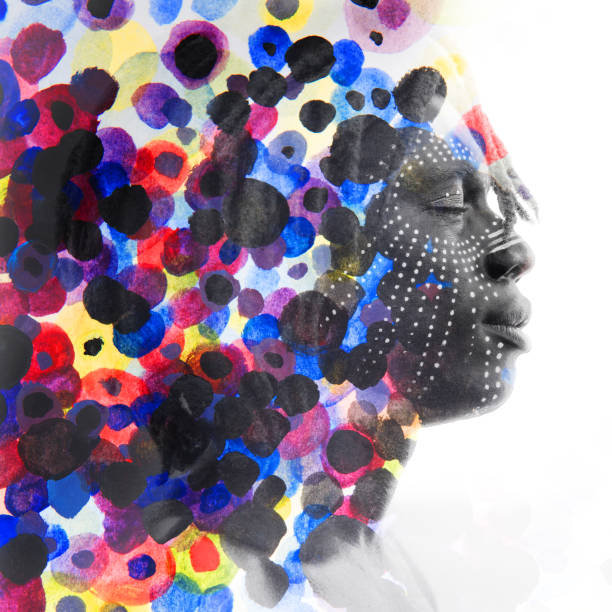 istock Paintography. African man with traditional style face paint dissolving behind colorful watercolor dots 884577790