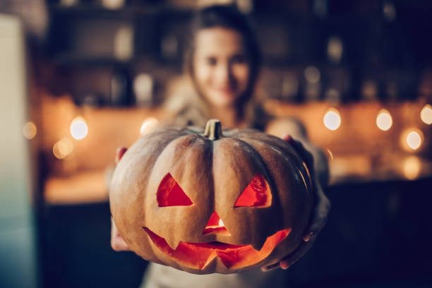 mujer con calabaza de halloween. - halloween pumpkin party carving fotografías e imágenes de stock