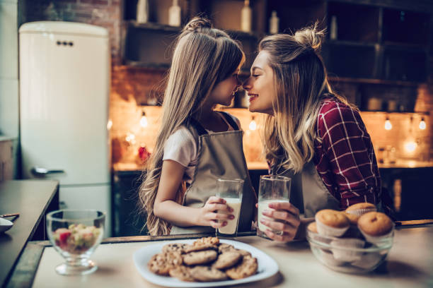 mãe com a filha na cozinha. - cookie women eating beautiful - fotografias e filmes do acervo