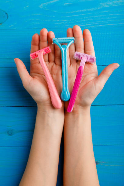 istock Shaving machine on palms close-up on blue wooden background 884625870