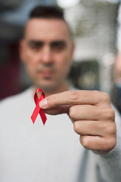 istock man with red ribbon for the fight against AIDS 884635358