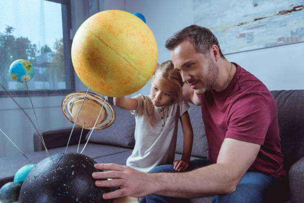 istock Father showing daughter planets 884638062