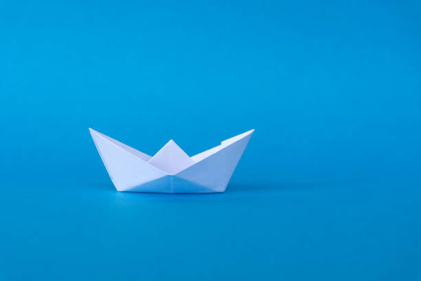 istock White Paper Boat on Blue Background 884641354