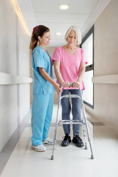 istock Nurse helping senior patient in using mobility walker 884647358