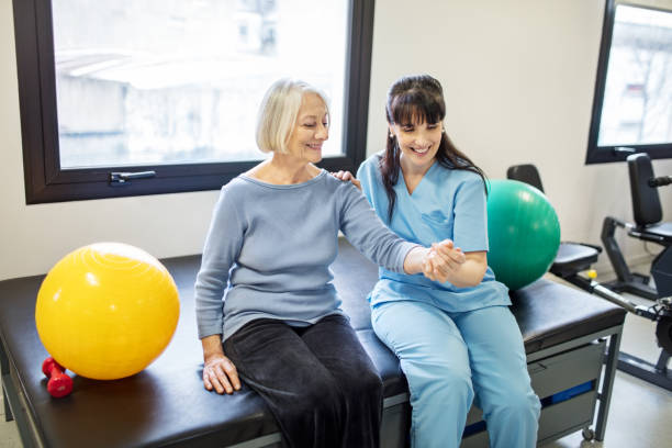 istock Nurse assisting senior woman with hand exercise 884651080