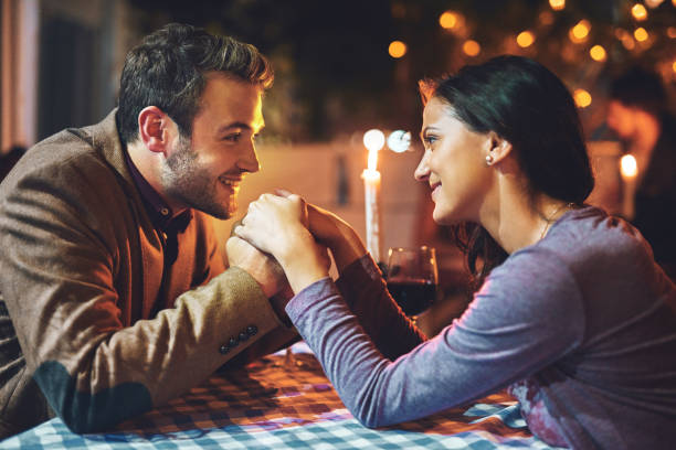 You are all that matters in this moment Cropped shot of an affectionate young couple having a romantic dinner in a restaurant candle light dinner stock pictures, royalty-free photos & images