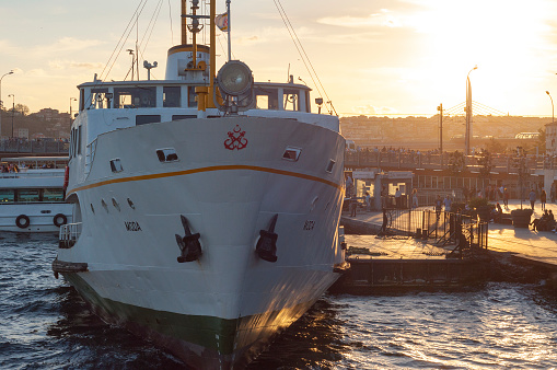 Istanbul, Turkey - September 2, 2016: Sunset view from the Golden or Halic in golden hour, passenger ferries and generic architecture of Eminonu and Karakoy, the historical districts of Istanbul, Turkey.