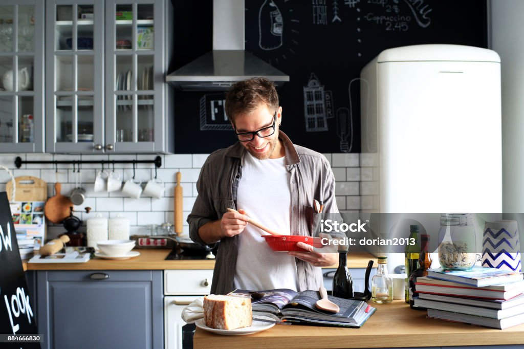 Young man cooking lunch Young man cooking lunch in the kitchen Adult Stock Photo