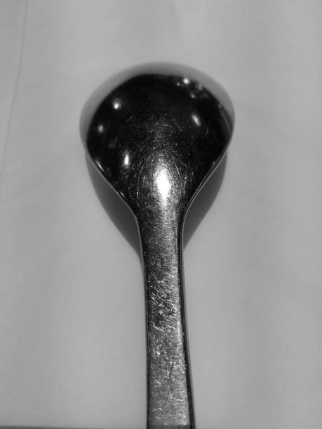 istock Thick silver spoon on white tissue paper in black and white 884671608