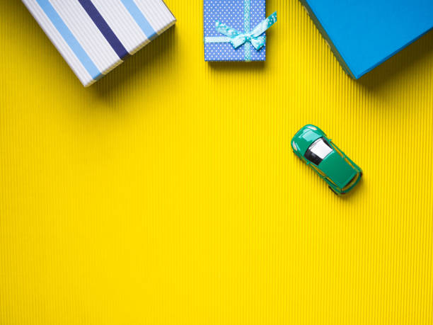 istock Gift boxes and toy car on yellow background 884671844