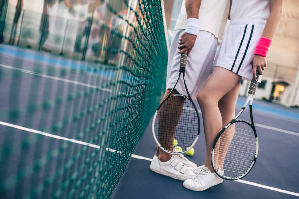 istock Couple on tennis court. 884671966