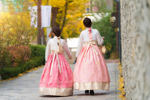 Asian Korean woman dressed Hanbok in traditional dress walking in Jeongdong-gil in Seoul, South Korea.