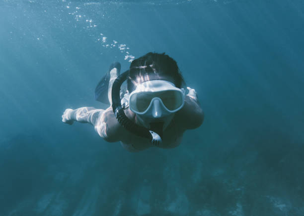 istock Young woman free diving. 884693674