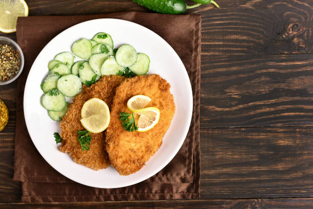 istock Tasty schnitzel with cucumber salad 884699050