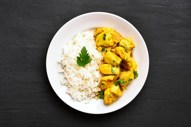 Chicken curry with rice Chicken curry with rice on black stone background. Top view, flat lay basmati rice stock pictures, royalty-free photos & images