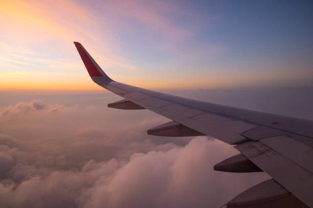 istock View of colorful twilight sky from plane window with wing in evening 884702828