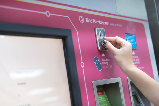 istock Woman hand inserts coin for exchange monorail chip in machine. Transportation concept 884702844