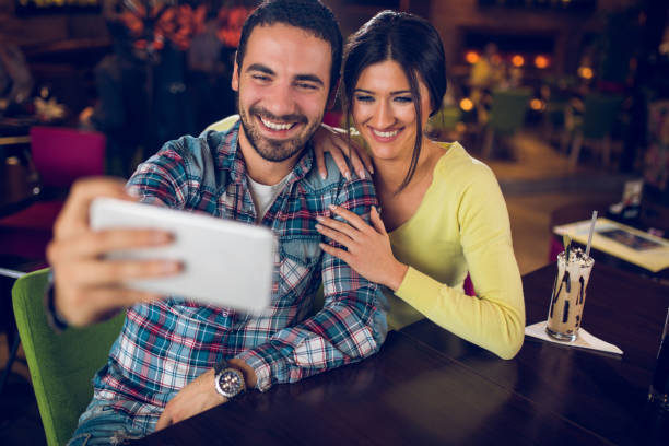 istock Young couple taking Selfie in a cafe. 884707796