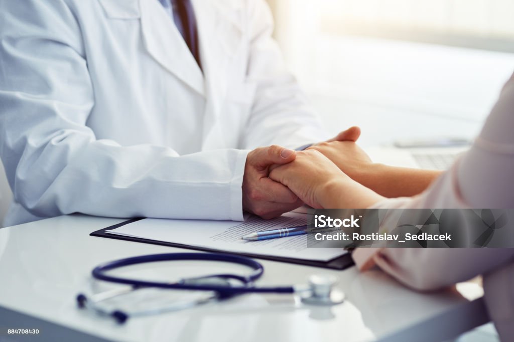 Freundlich männlichen Arzt den Patienten beruhigend und hält seine Hände - Lizenzfrei Arzt Stock-Foto