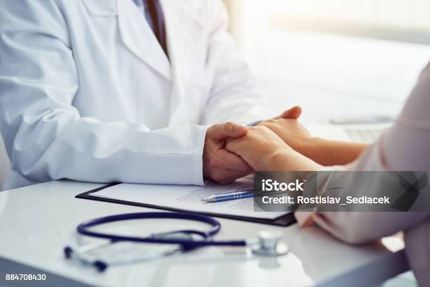 Friendly Male Doctor Reassuring The Patient And Holding His Hands Stock Photo - Download Image Now