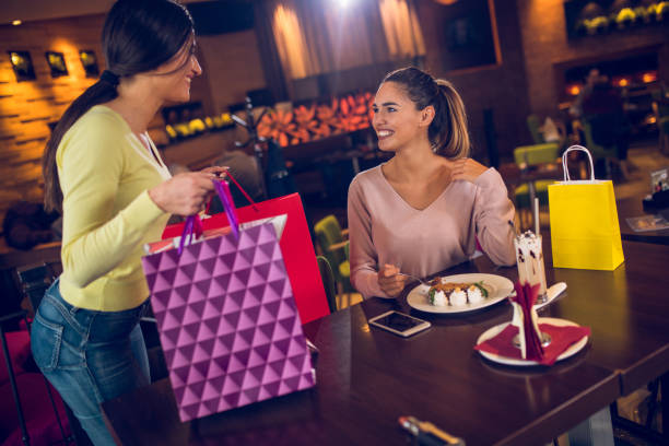 istock Two women having fun in cafe after shopping 884713554
