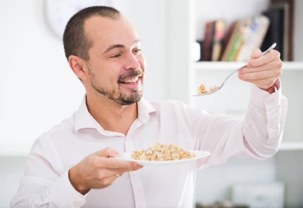 istock Positive young man eating porridge 884723504