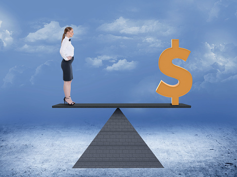 Businesswoman and dollar sign balancing on seesaw