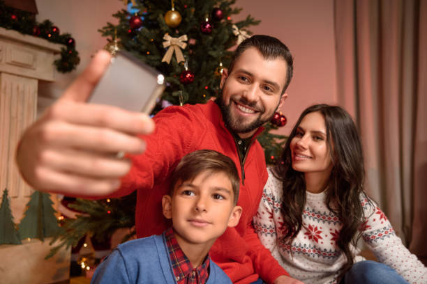istock family taking selfie at christmas 884727586