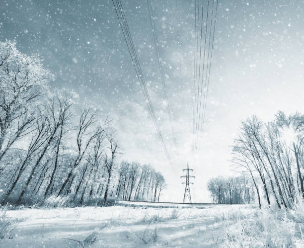 Torri di linea elettrica nella tempesta invernale con una bufera di neve - foto stock