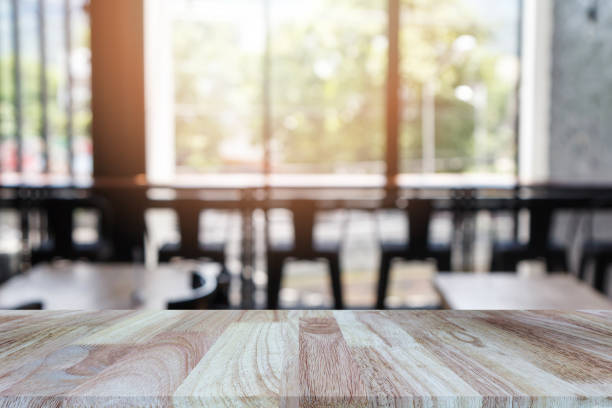 istock Wooden tabletop on blurred restaurant or coffee shop background, can be used for display or montage your products 884737252