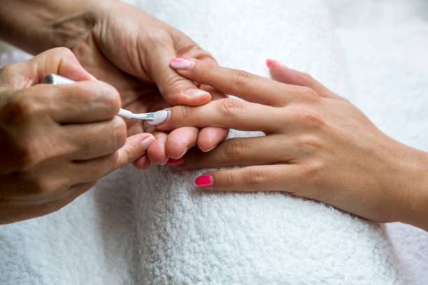 istock Beautician applying red varnish to finger nails. 884762410