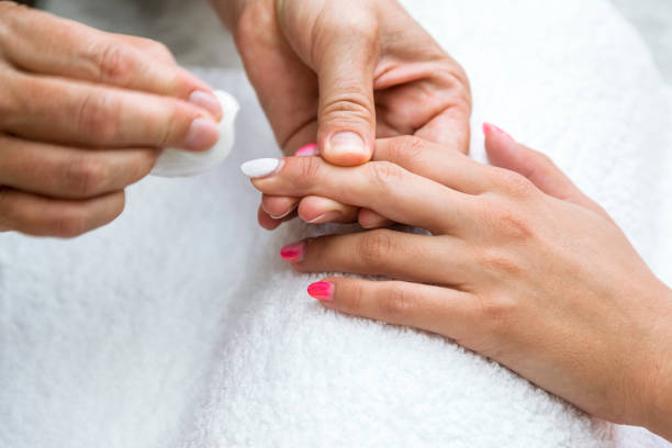 Beautician applying red varnish to finger nails. stock photo