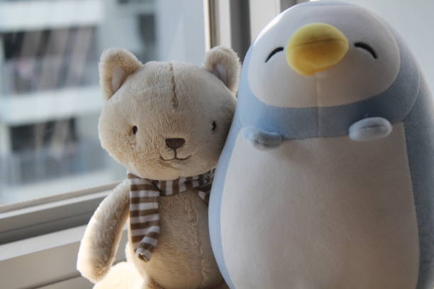 istock Bear toy with cup sitting by the window in shadows 884764930