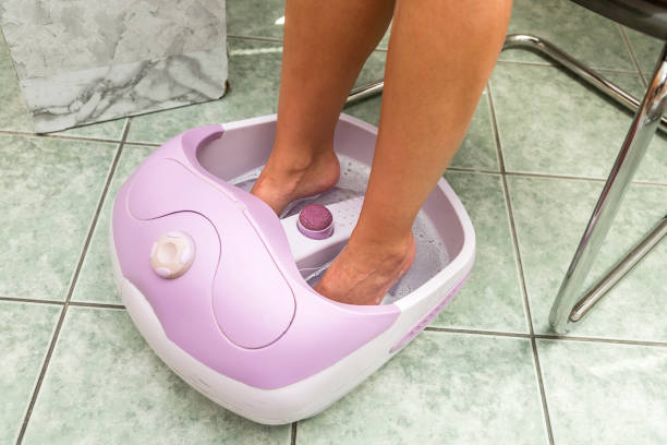 istock Female feet in a vibrating foot massager. 884775826