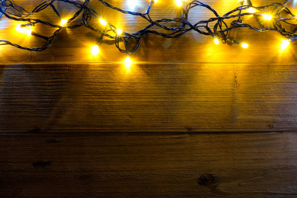 istock Christmas light on wood background. 884775926