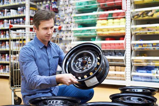istock Man chooses disks for car in store. 884783046