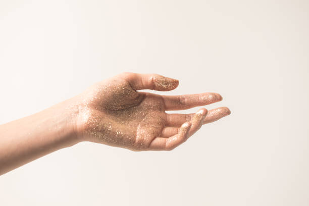 istock female hand in golden glitter 884791940