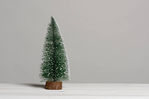 istock Small christmas tree on white wooden table 884795886