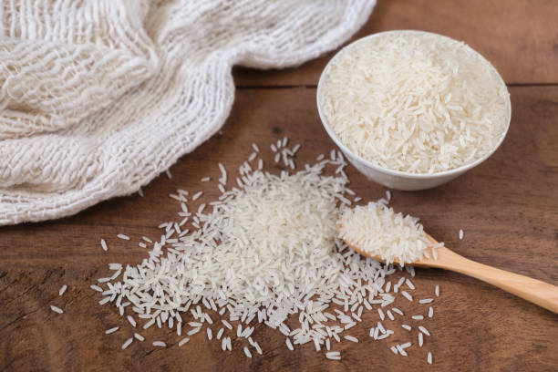 istock Organic rice, Jasmine rice with spoon on wooden table background 884801178