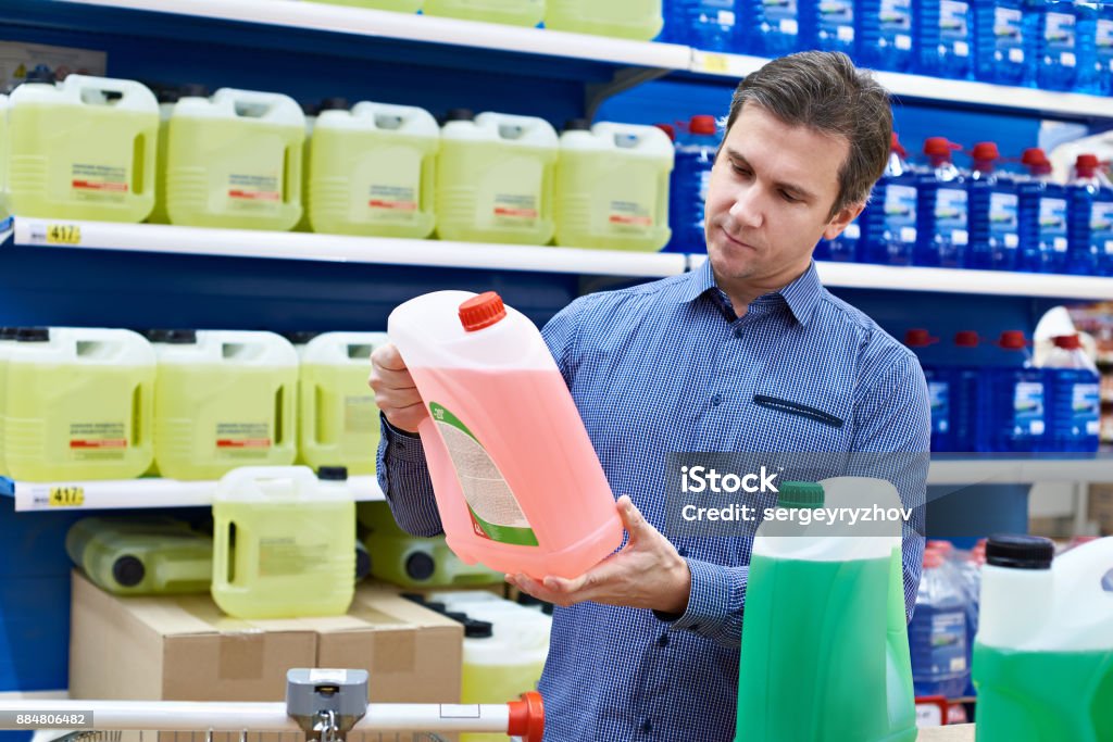 Man buys windshield washer fluid in shop Man buys windshield washer fluid in the supermarket Adult Stock Photo
